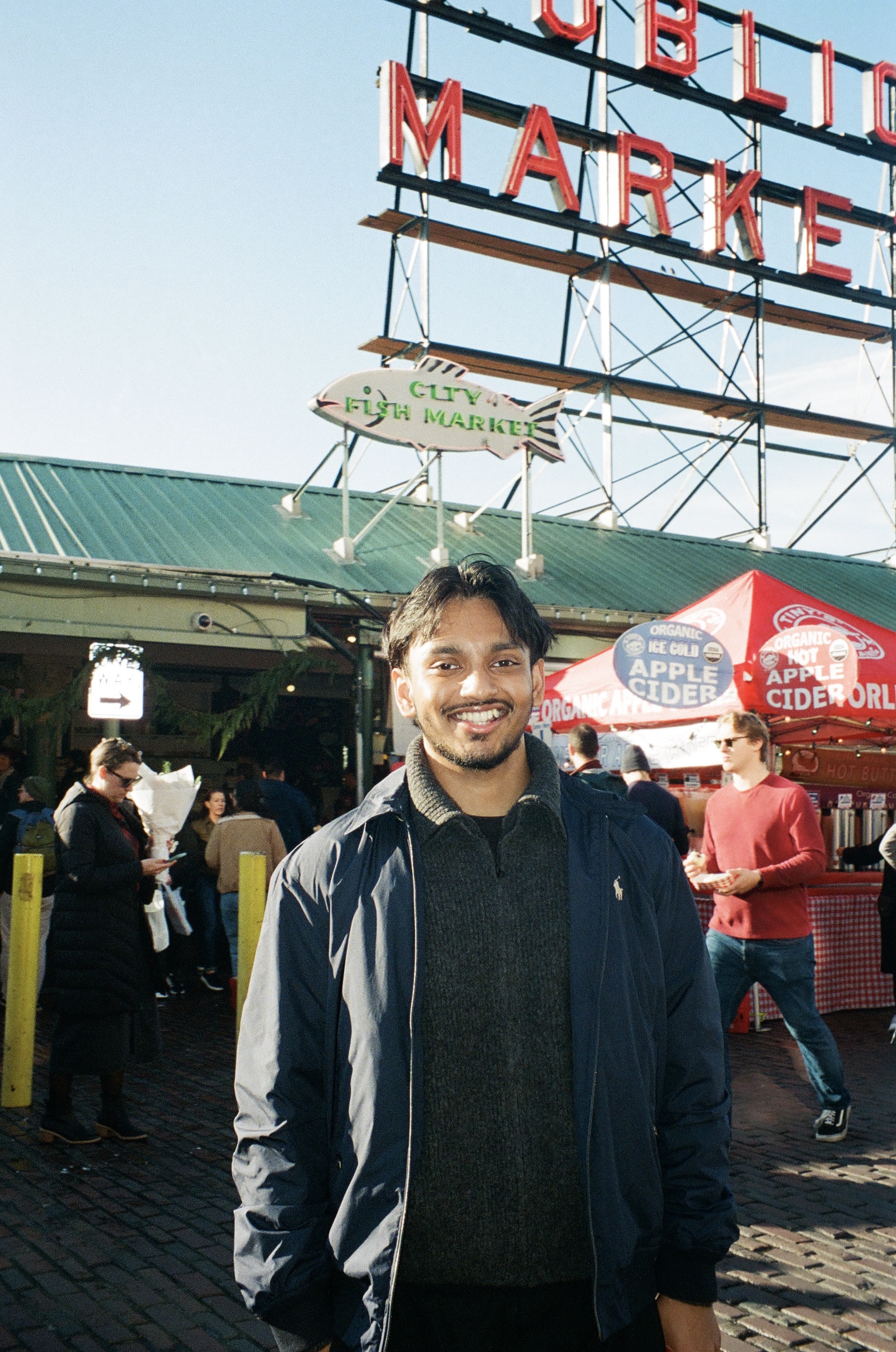 Smiling in front of the Pike Place Market sign